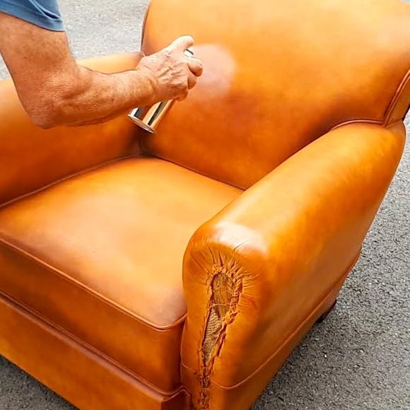 Application d'une crème pour assouplir le cuir d'un fauteuil club